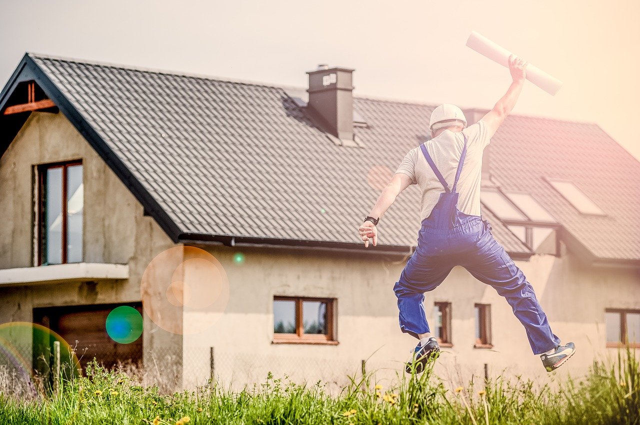 Man jumping for joy in front of house